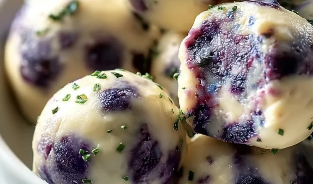 Blueberry cheesecake protein bites on a plate with fresh berries
