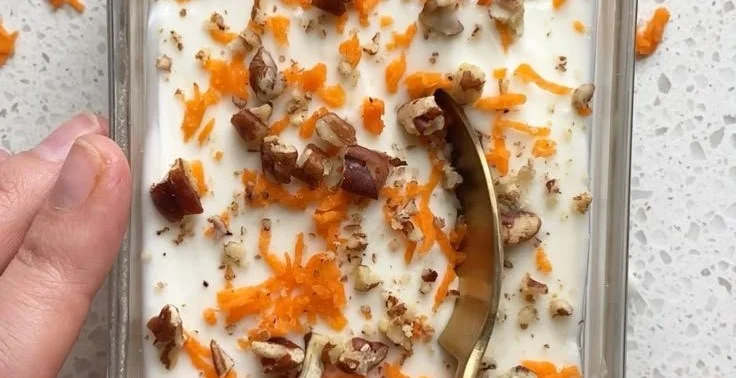 High protein carrot cake overnight oats in a glass jar with toppings.