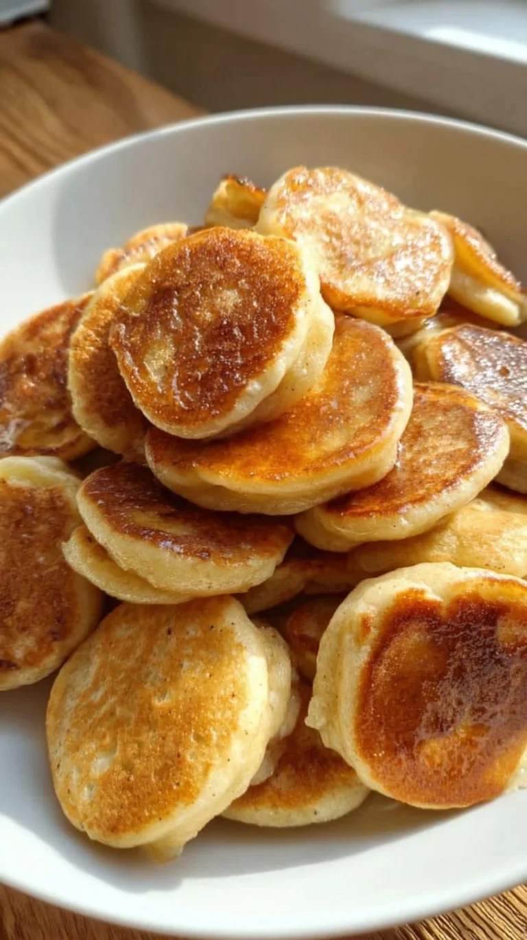 Plate of mini banana pancake bites topped with syrup and fresh fruit